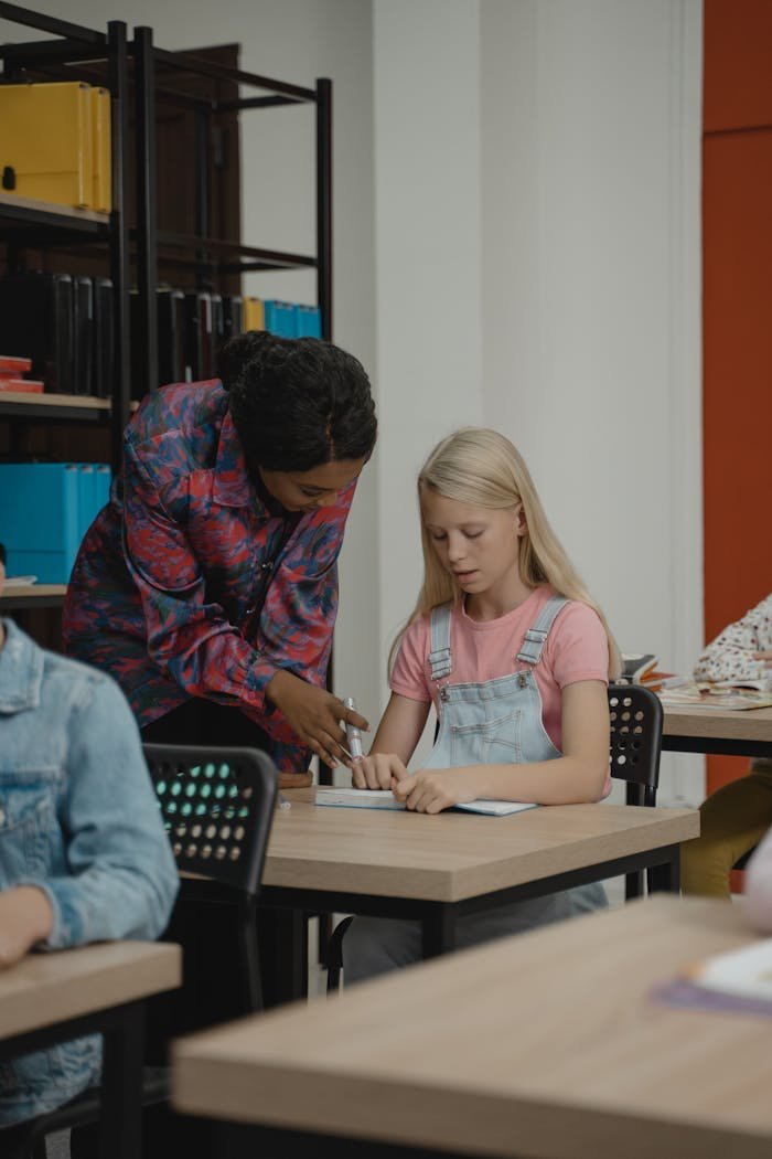 A teacher assisting a student in a classroom, fostering learning and engagement.